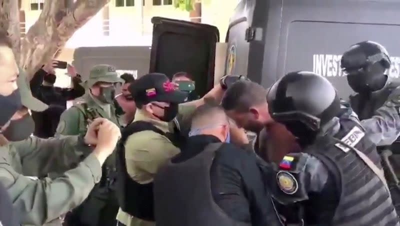 Venezuelan soldiers wearing face masks surround a suspect moved from a helicopter after what Venezuelan authorities described was a "mercenary incursion", at an unknown location in this still frame obtained from Venezuelan government TV video