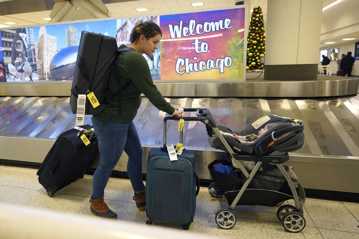 Wimberly Hoogendoorn from Houston, Texas, gathers her luggage at Chicago's Midway Airport for a family holiday visit just days before a major winter storm Tuesday, Dec. 20, 2022, in Chicago. (AP Photo/Charles Rex Arbogast)