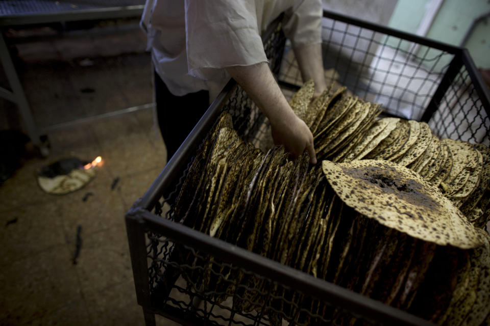 An ultra-Orthodox Jewish man selects special matzoh, a traditional handmade Passover unleavened bread, at a bakery in Bnei Brak near Tel Aviv, Israel. Thursday, April 10, 2014. Jews are forbidden to eat leavened foodstuffs during the Passover holiday. Passover celebrates the biblical story of the Israelites' escape from slavery and exodus from Egypt. (AP Photo/Oded Balilty)