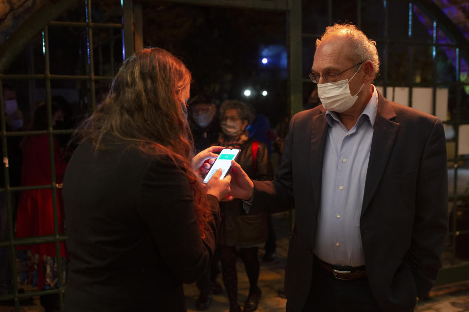 A man presents his "green passport," proof that he is vaccinated against the coronavirus, on opening night at the Khan Theater for a performance where all guests were required to show proof of vaccination or full recovery from the virus, in Jerusalem, Tuesday, Feb. 23, 2021. (AP Photo/Maya Alleruzzo)