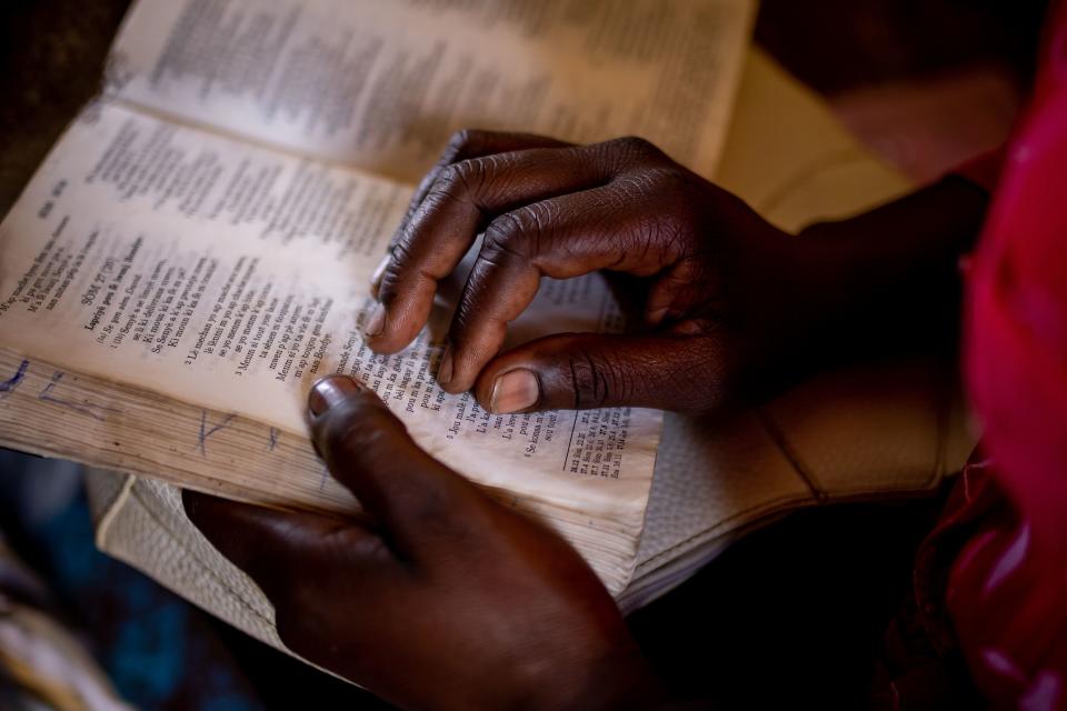 Jean-Mary reads scriptures written in Haitian Creole during a bible study in Batey Libertad. | Spenser Heaps, Deseret News