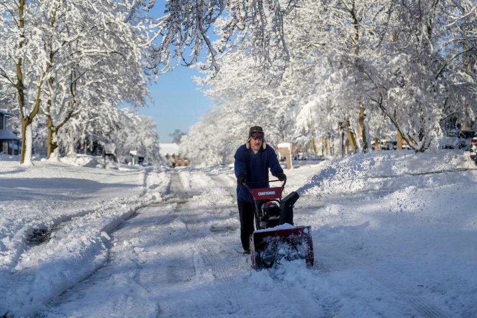 Ross Weaver plows out a section of road in front of his home in Farmington Hills, Michigan, on Saturday after a winter storm left several inches of snow across the Metro Detroit area. (AP)