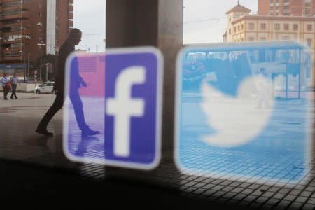 Facebook and Twitter logos are seen on a shop window in Malaga, Spain, June 4, 2018. REUTERS/Jon Nazca/File Photo