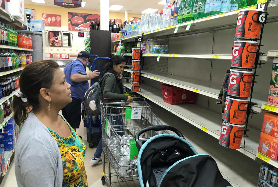 A shopper in Sedano's Supermarket looks at nearly empty water shelves in the Little Havana neighborhood in Miami.