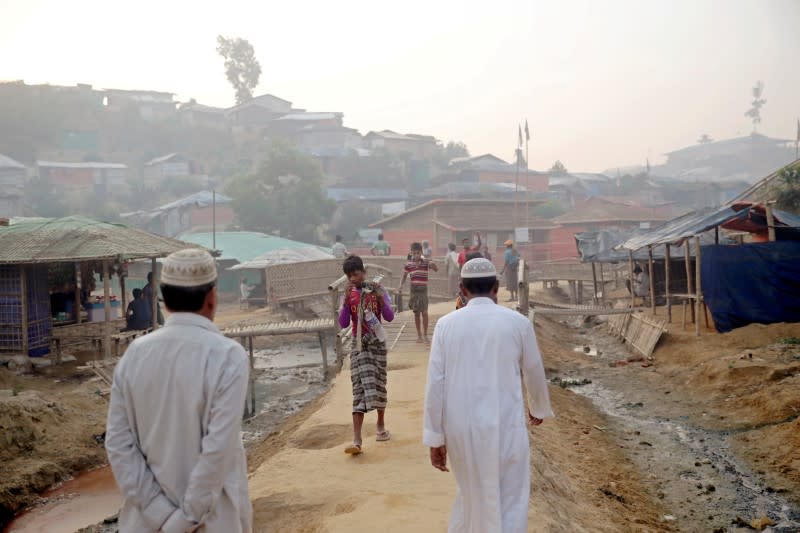 FILE PHOTO: Rohingya refugees walk on a road at the Balukhali camp in Cox's Bazar