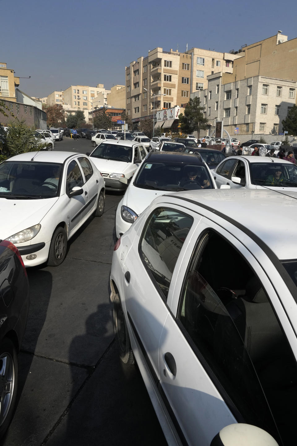 Cars line up outside a gas station in Tehran, Iran, Monday, Dec. 18, 2023. Nearly 70% of Iran's gas stations went out of service on Monday following possible sabotage — a reference to cyberattacks, Iranian state TV reported. (AP Photo/Vahid Salemi)