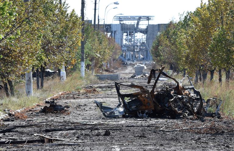 A destroyed vehicle lies on a road leading to the remains of Lugansk International Airport, eastern Ukraine, September 11, 2014