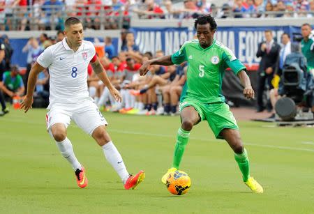 Nigeria defender Efe Ambrose (5) passes the ball as United States forward Clint Dempsey (8) defends during the first half at EverBank Field. Mandatory Credit: Kim Klement-USA TODAY Sports