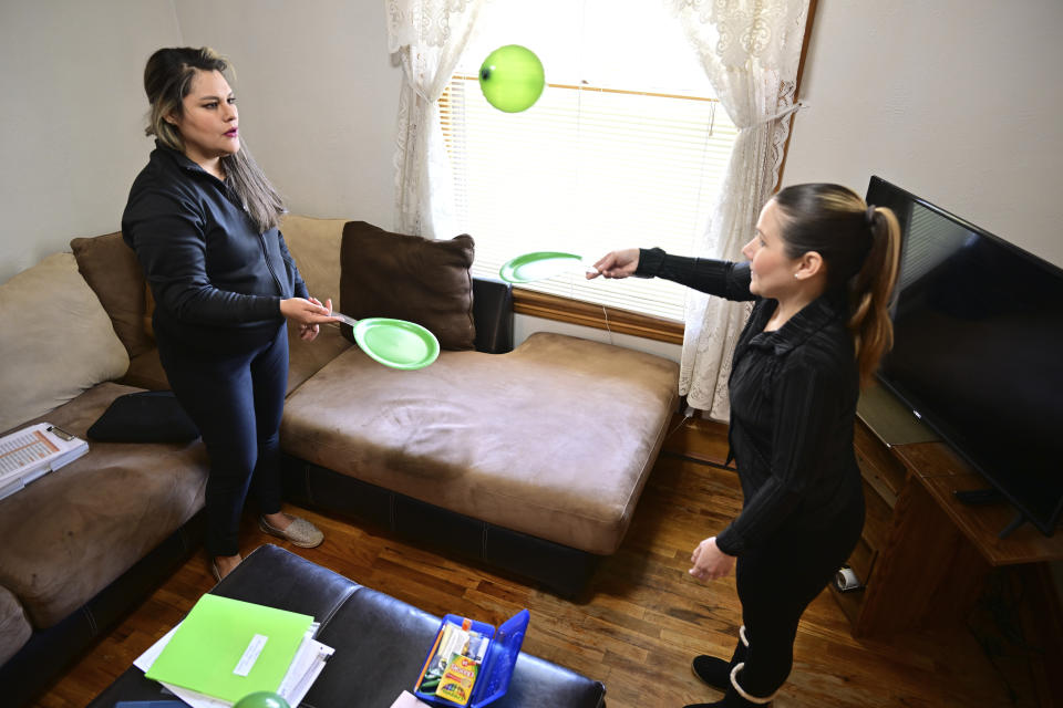 Isabel Valencia, right, and Home Visit HIPPY (Home Instruction for Parents of Preschool Youngsters) instructor Mayra Ocampo, engage in a mobility lesson in Valencia's living room in Pueblo, Colo., Wednesday, Feb. 28, 2024. (AP Photo/Eric Lars Bakke)