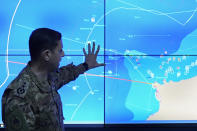 Col. Haitham Dinnawi, commander of the Lebanese navy, stands in front of a map to explain where a Lebanese navy boat attempted to force a small boat with migrants to return to the shore before it sank while carrying nearly 60 people overnight, during a press conference at the control room of the Lebanese navy headquarters, in Beirut, Lebanon, Sunday, April 24, 2022. The Lebanese military announced that 47 people were rescued and several bodies were recovered. Several survivors told local TV stations that the Lebanese navy ship rammed their migrant boat twice, damaging it. (AP Photo/Hussein Malla)