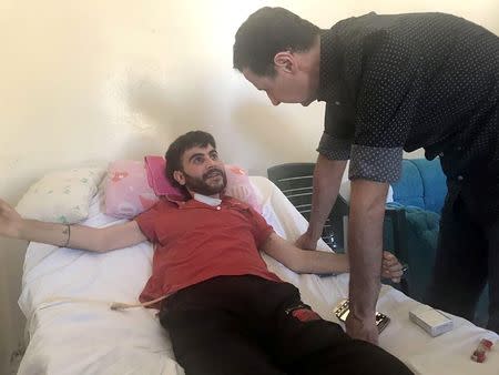 Syria's President Bashar al-Assad visits an injured soldier in Hama province. SANA/Handout via REUTERS