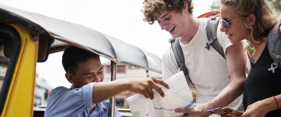 Tourists couple asking tuk tuk native taxi driver for direction