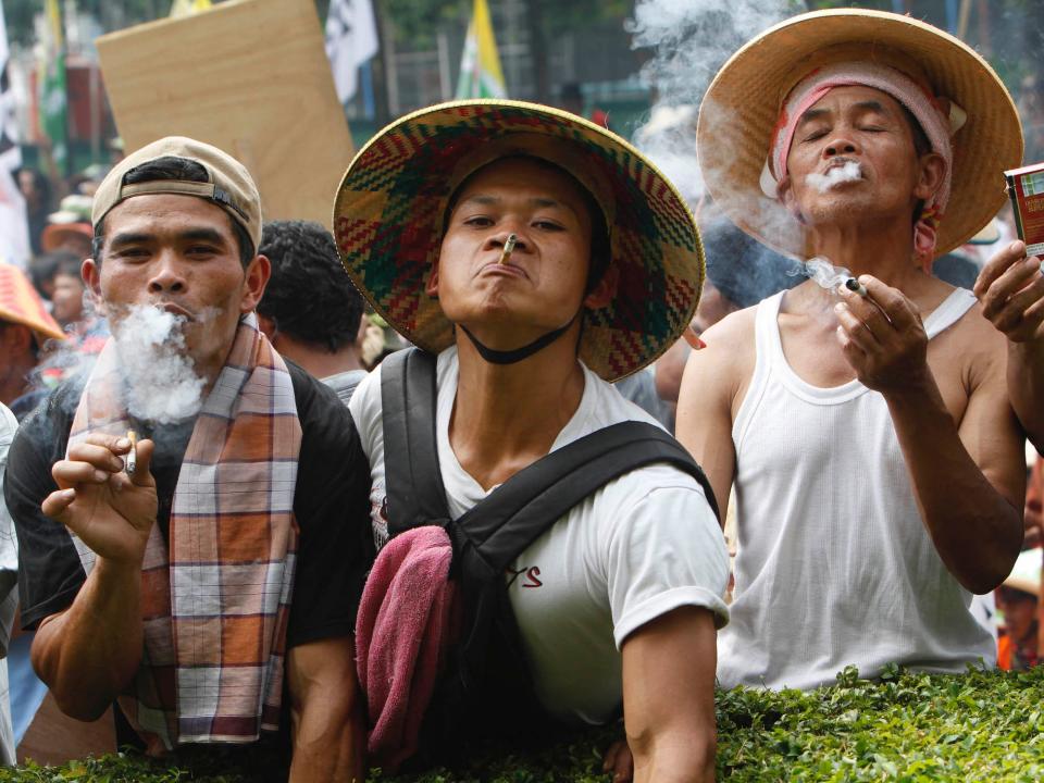 Tobacco farmers smoke cigarettes during a protest in Jakarta.