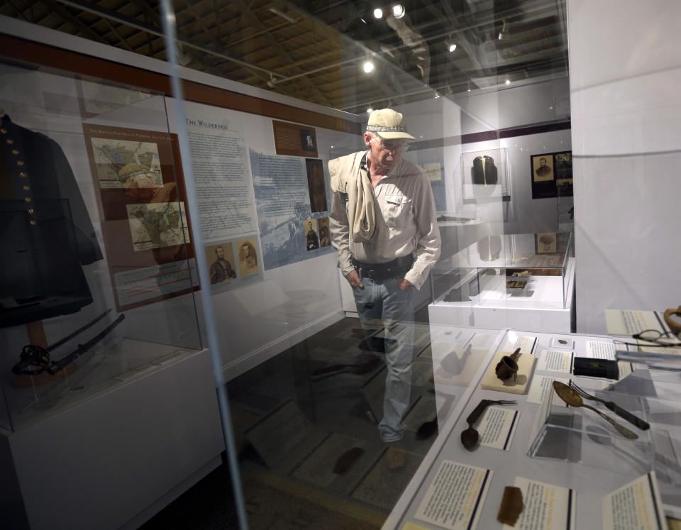 In this Wednesday, June 26, 2013 photo, David Anderson, of Seattle, visits a Civil War display highlighting artifacts from New York, at the New York State Military Museum, in Saratoga Springs, N.Y. The exhibit, titled "New York in the Civil War," will be a permanent part of the museum, which tells New York's military history from the Revolutionary War to the Iraq and Afghanistan wars. (AP Photo/Mike Groll)