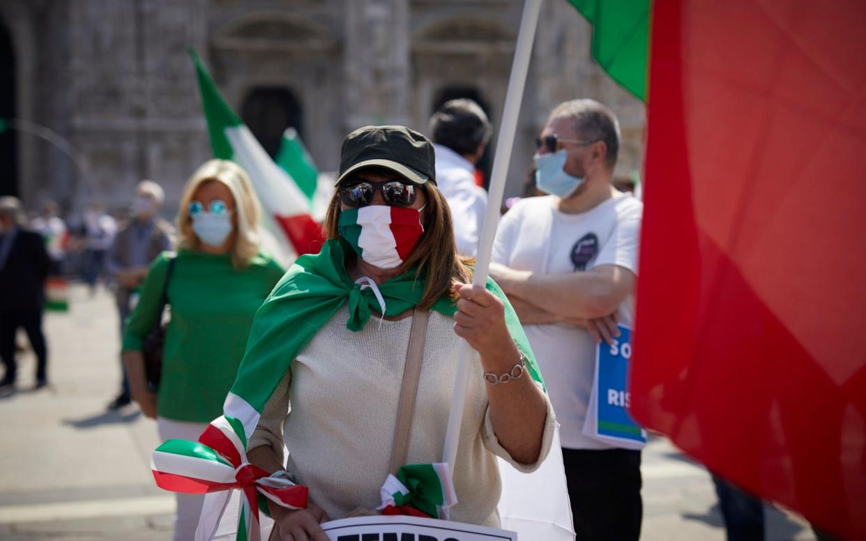 People demonstrate and wave Italian flags during a protest against the Italian government for the economic problems related to the pandemic, Milan - Getty