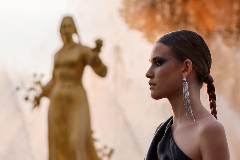 FILE PHOTO: A model presents a creation by Russian designer Igor Chapurin during the Moscow Fashion Week at fountain at the Exhibition of Achievements of National Economy (VDNH) in Moscow