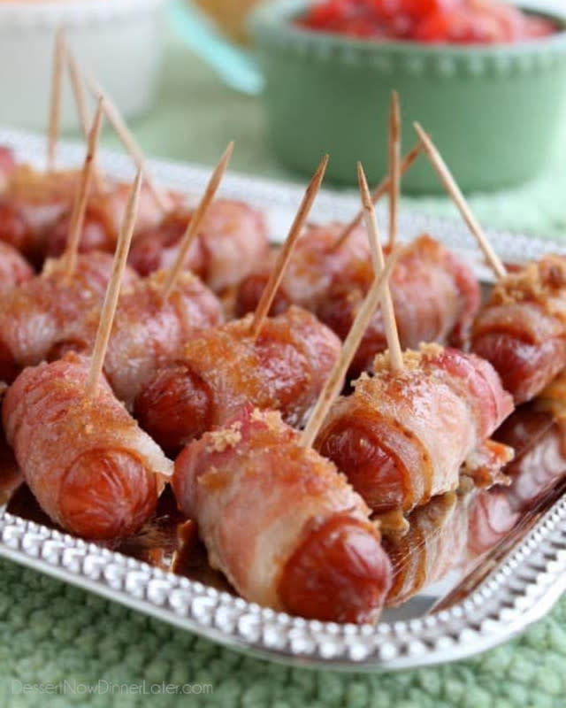 <p>Dessert Now Dinner Later</p><p>These savory cocktail sausages are wrapped in bacon and sprinkled with brown sugar, then baked to perfection. An appetizer that everyone loves!</p><p><a href="https://www.dessertnowdinnerlater.com/bacon-wrapped-mini-sausages-with-brown-sugar/" rel="nofollow noopener" target="_blank" data-ylk="slk:Get the Recipe;elm:context_link;itc:0;sec:content-canvas" class="link ">Get the Recipe</a></p>