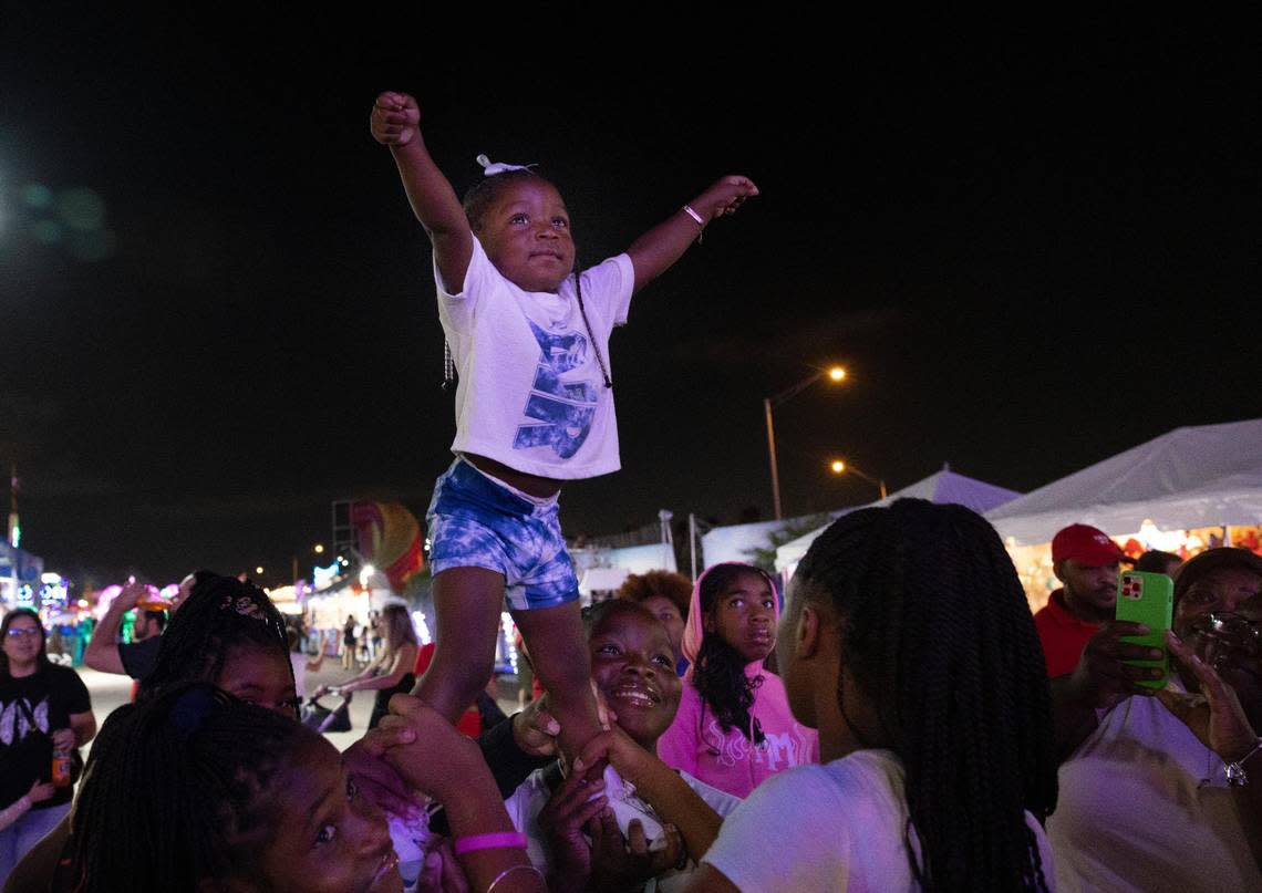 Lyric Johnson, 2, cheers in excitement for the tree lighting on the grand opening of Santa’s Enchanted Forest.