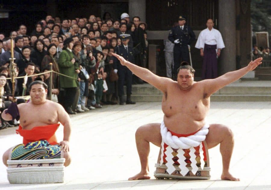 Accompanied by a sword-bearer, grand champion Akebono performs the ring-entrance ritual during the annual New Year's dedication at Meiji Shrine in Tokyo, on Jan. 8, 1997. Hawaii-born Akebono, one of the greats of sumo wresting and a former grand champion, is reported to have died earlier this month of heart failure while receiving care at a hospital in Tokyo, the United States Forces in Japan said in a statement on Thursday, April 11, 2024. (AP Photo/Koji Sasahara, File)