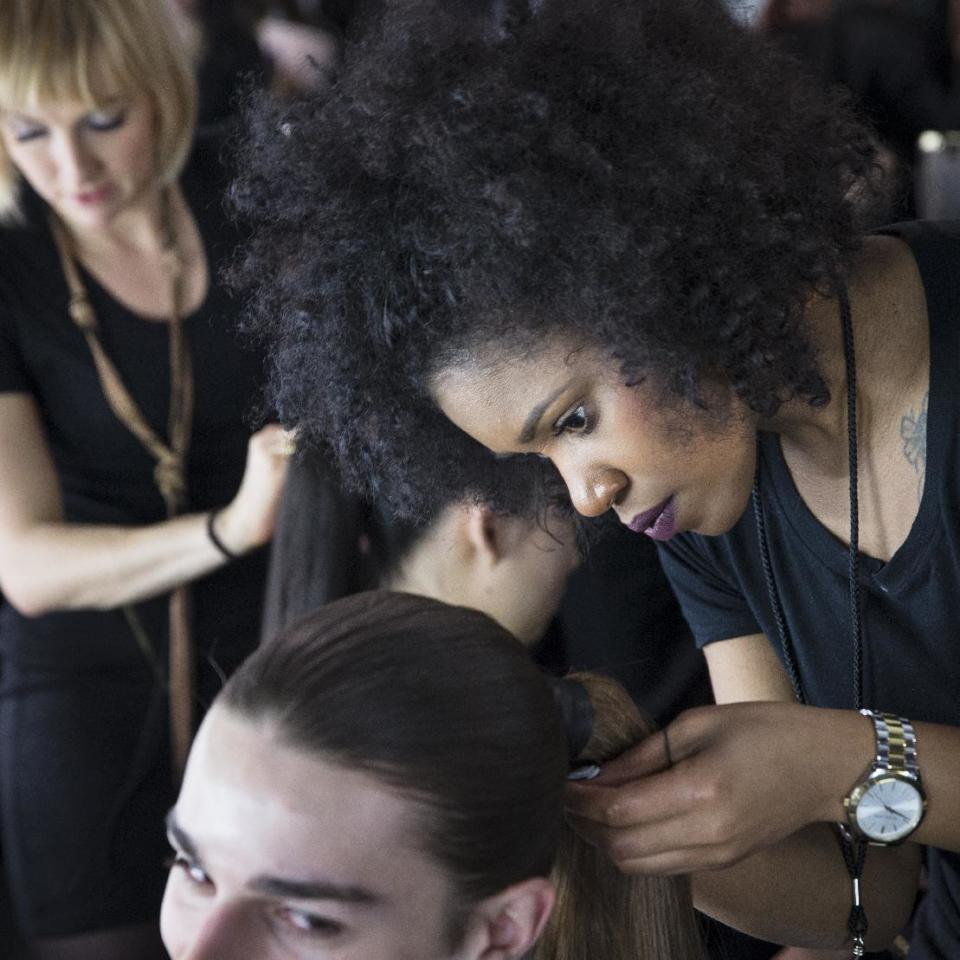 A model's hair is prepped backstage before the Carmen Marc Valvo Fall 2014 collection is modeled during Fashion Week, Friday, Feb. 7, 2014, in New York. (AP Photo/John Minchillo)