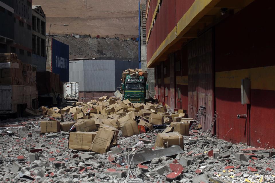 A truck remains covered by debris and boxes of fallen merchandise that fell from the earthquake ravaged Duty Free Zone of Iquique, in Iquique, Chile, Friday, April 4, 2014. Following a magnitude-8.2 earthquake early in the week, soldiers have kept a close watch on supermarkets and gas stations to prevent looting as many people continued to line up on Friday for gasoline, water and food. The city remained largely peaceful and no new major damage or casualties were reported from the continuing aftershocks that have rattled the sleep-deprived citizens of Chile's north. (AP Photo/Luis Hidalgo)