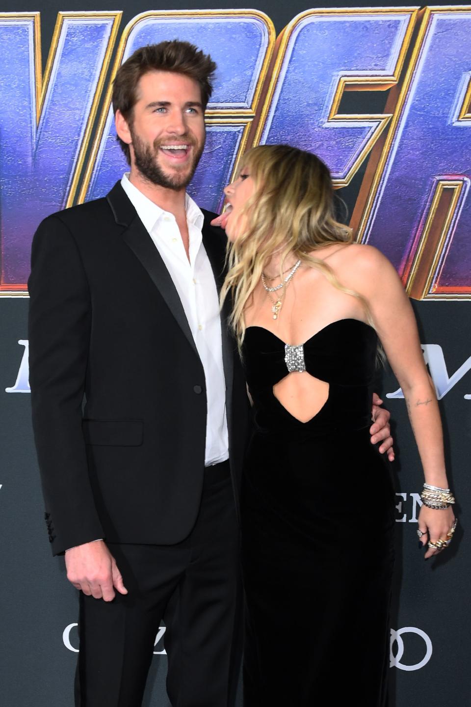 Liam Hemsworth laughs as Miley Cyrus licks him at the Endgame premiere
