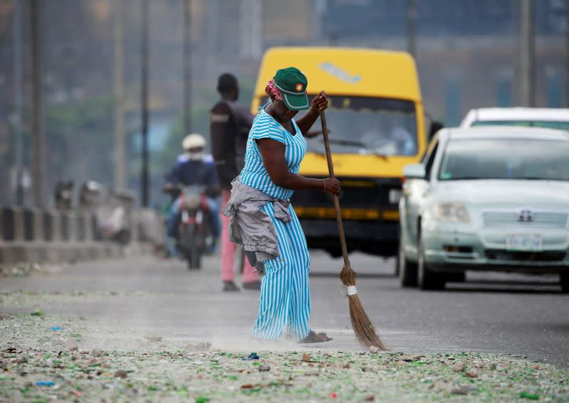 A woman cleans a street in Lagos