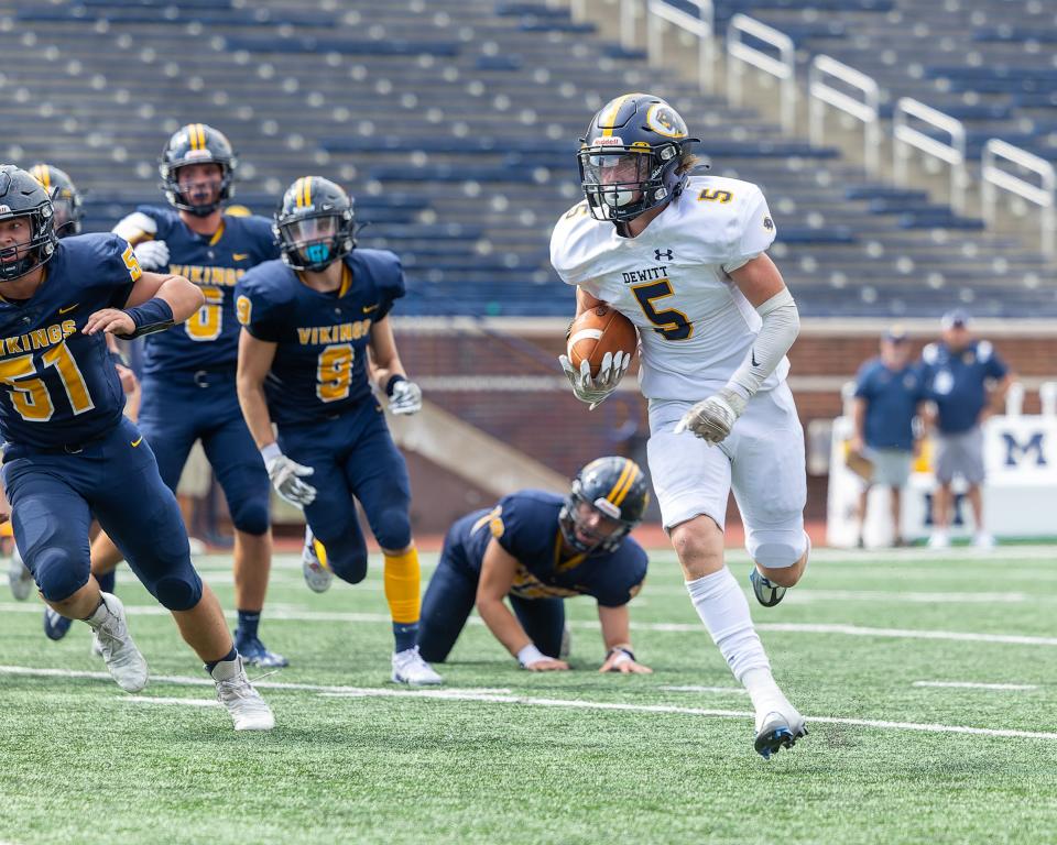 Dewitt's Abram Larner gets in front of the Haslett defense in the Battle of the Big House Thursday, Aug. 25, 2022 in Ann Arbor.