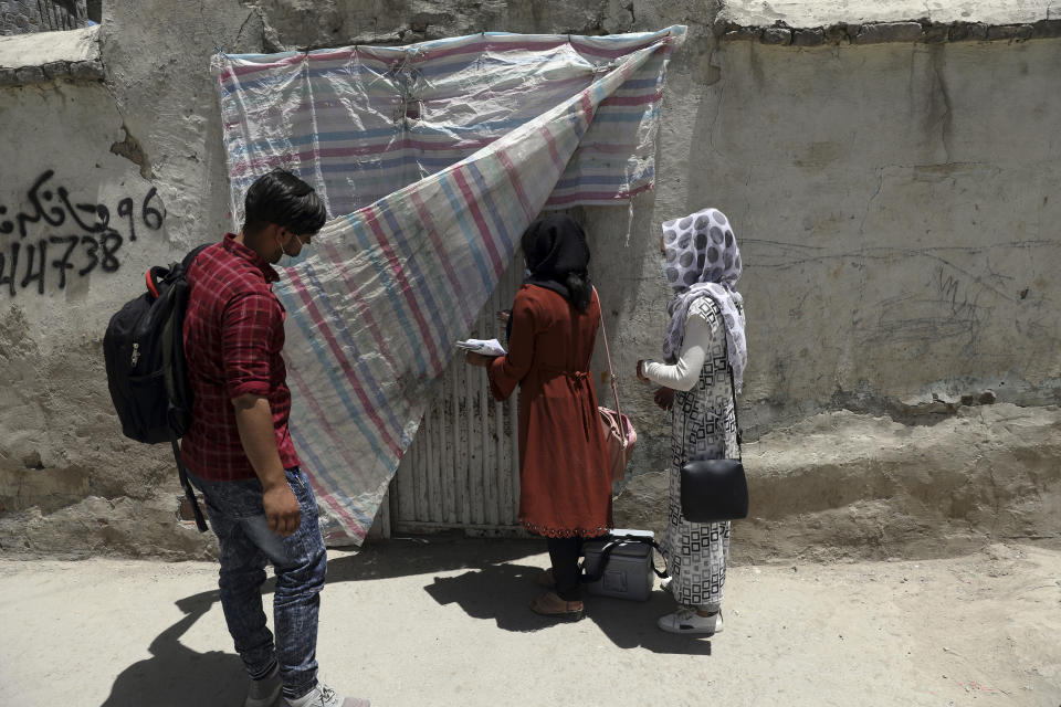 Health workers go door to door during a polio vaccination campaign in the old part of Kabul, Afghanistan, Tuesday, June 15, 2021. Gunmen on Tuesday targeted members of polio teams in eastern Afghanistan, killing some staffers, officials said. (AP Photo/Rahmat Gul)