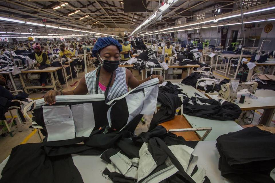 A woman wearing a mask works at the MBI factory at the industrial park Sonapi in Port-au-Prince on April 21, 2020. -