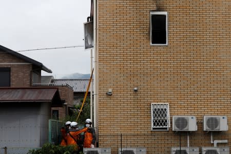 Firefighters check the torced Kyoto Animation building in Kyoto