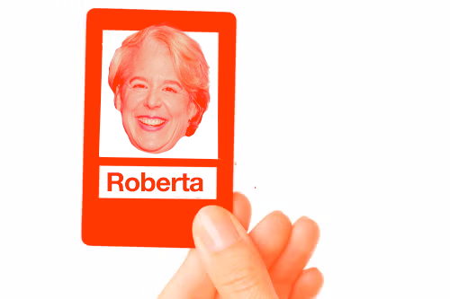 A hand holding a "Guess Who?" game card with Roberta Kaplan's face on it.