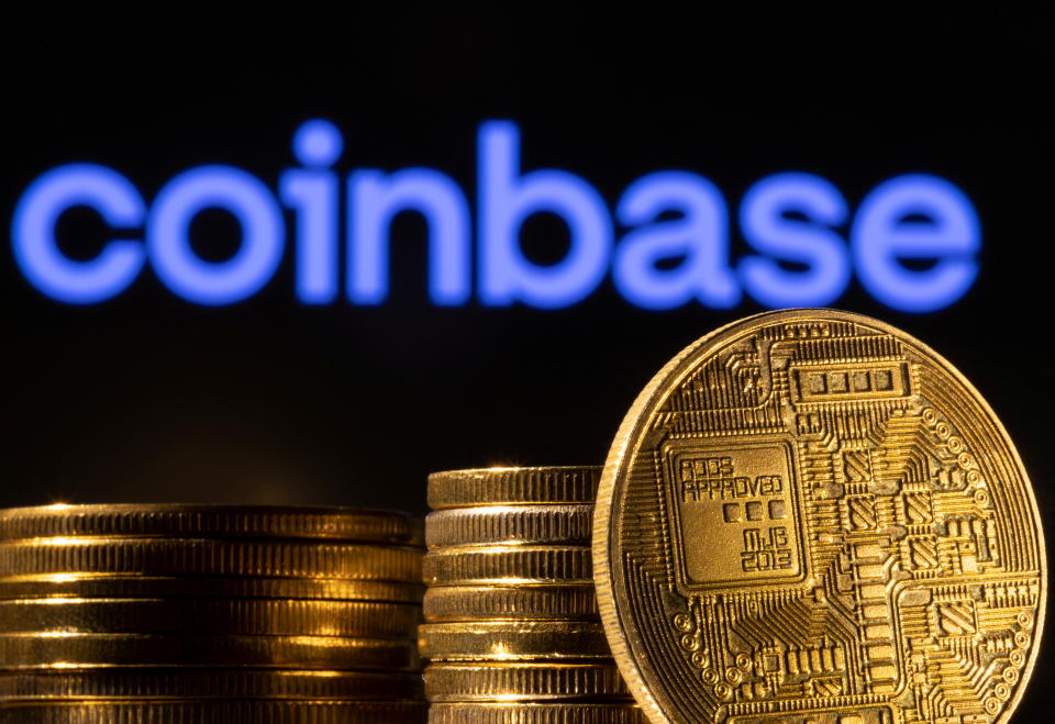 Ib tug sawv cev ntawm lub cryptocurrency yog pom nyob rau hauv pem hauv ntej ntawm Coinbase logo nyob rau hauv no illustration coj, Lub peb hlis ntuj 4, 2022. REUTERS/Dado Ruvic/Illustration