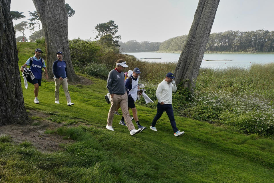 Paul Casey, from right, Ian Poulter and Webb Simpson walk on the 18th hole during the first round of the PGA Championship golf tournament at TPC Harding Park Thursday, Aug. 6, 2020, in San Francisco. (AP Photo/Charlie Riedel)