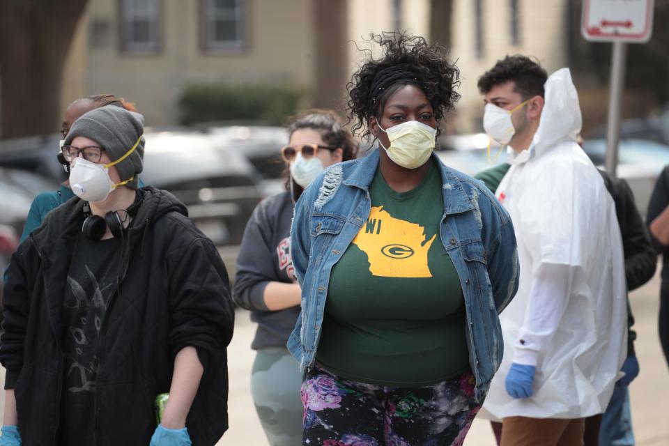 Masked Wisconsin residents wait to vote in Milwaukee on April 7, 2020.