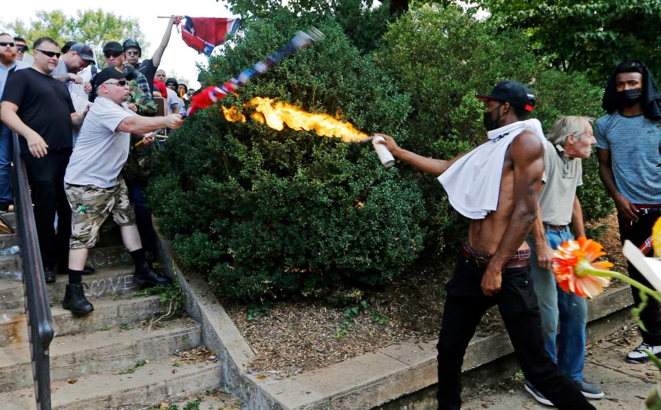 A counter demonstrator uses a lighted spray can Aug. 12, 2017, against a white nationalist demonstrator at the entrance to Lee Park in Charlottesville, Va