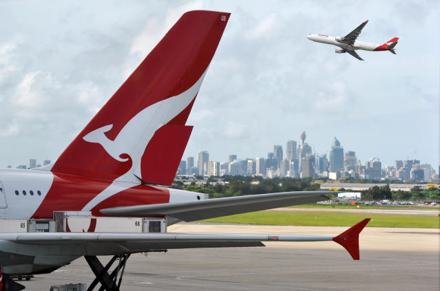 &quot;Sydney, Australia - March, 14th 2012: Quantas aeroplanes and tail fin with the distant view of downtown Sydney - Sydney Airport&quot;