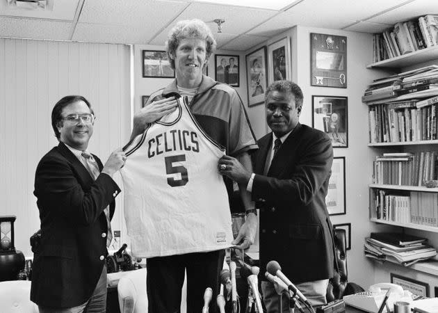 Bill Walton, center, gets some help holding up his jersey from Boston Celtics General Manager Jan Volk, left, and K.C. Jones during a press conference in Boston, Sept. 13, 1985. Walton comes to the Celtics from the Los Angeles Clippers. (AP Photo/Dave Tenenbaum)