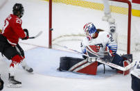 A shot by Canada's Marie-Philip Poulin, left, hits the post as U.S. goalie Nicole Hensley looks back during the third period of the IIHF hockey women's world championships title game in Calgary, Alberta, Tuesday, Aug. 31, 2021. (Jeff McIntosh/The Canadian Press via AP)