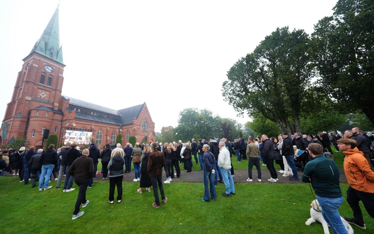 People watching on a big screen outside the funeral service of Sven-Goran Eriksson at Fryksande Church in Torsby, Sweden