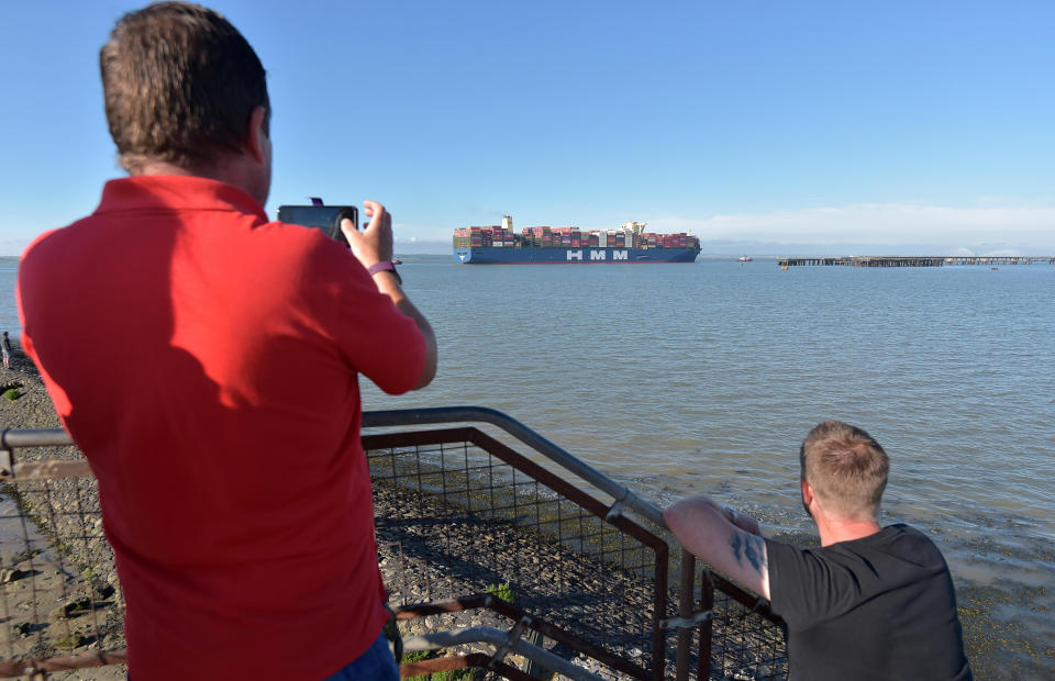 Two men stop to take pictures as the huge vessel arrives in the UK for the first time.