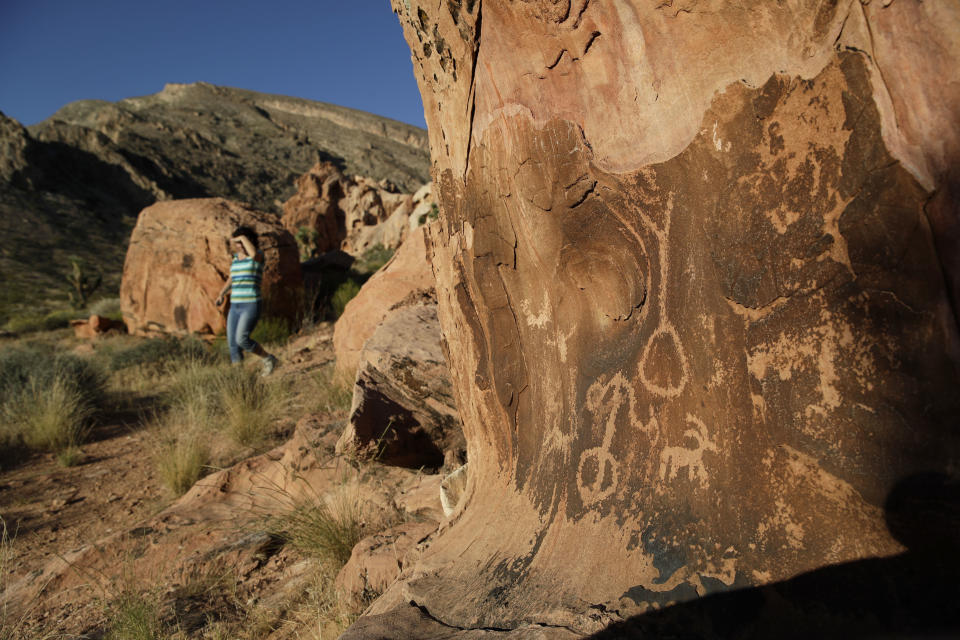 FILE - In this May 26, 2017, photo, Susie Gelbart walks near petroglyphs at the Gold Butte National Monument near Bunkerville, Nev. U.S. Interior Secretary David Bernhardt says he has no plans for additional changes to Gold Butte and other national monuments as recommended by his predecessor, but says it's ultimately up to President Donald Trump. (AP Photo/John Locher, File)