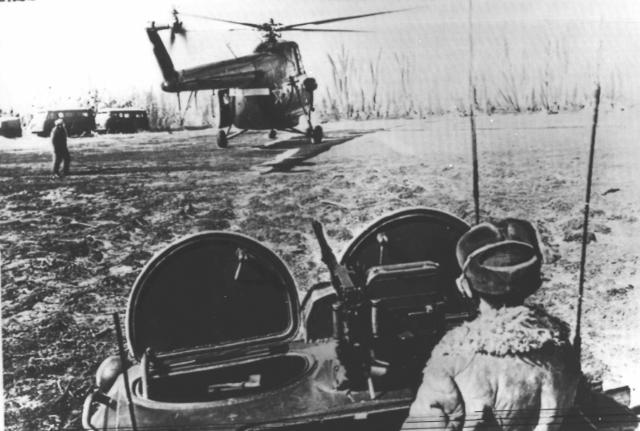 FILE - A Soviet soldier stands atop his armored personnel carrier as a helicopter lands ahead of him near the Ussuri River during a border skirmish along the Soviet-Chinese border in March 1969. China’s leader Xi Jinping just concluded a three-day visit with Russian President Vladimir Putin, a warm affair in which the two men praised each other and spoke of a profound friendship. It’s a high in a complicated, centuries-long relationship in which the two countries have been allies and enemies. (AP Photo/TASS, File)