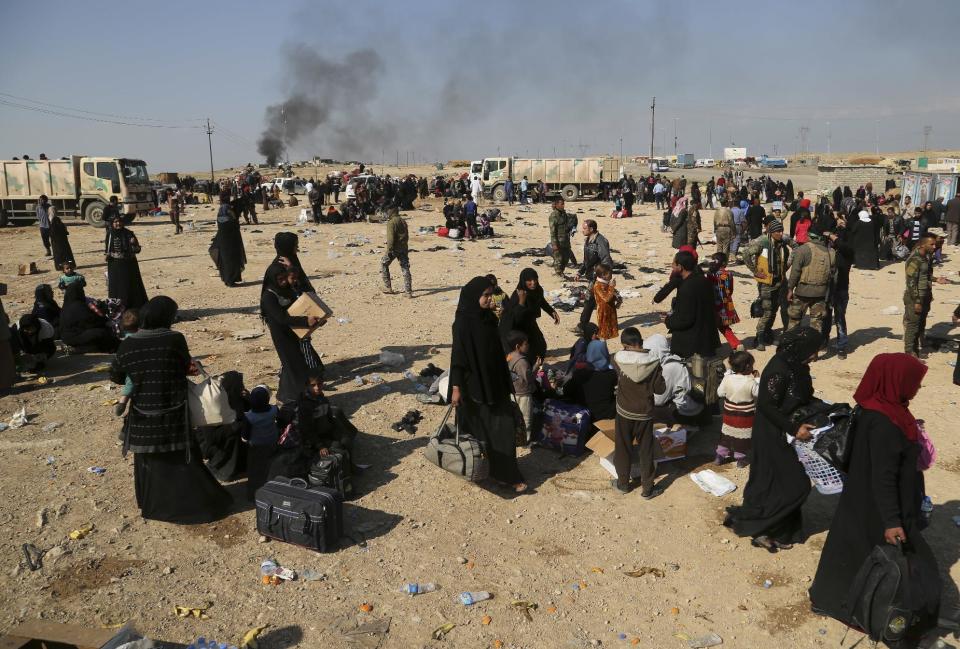 Displaced Iraqis who fled their homes due to fighting between Iraqi security forces and Islamic State militants wait to be transferred to camps for displaced people, on the western side of Mosul, Iraq, Wednesday, March 8, 2017. (AP Photo/Khalid Mohammed)