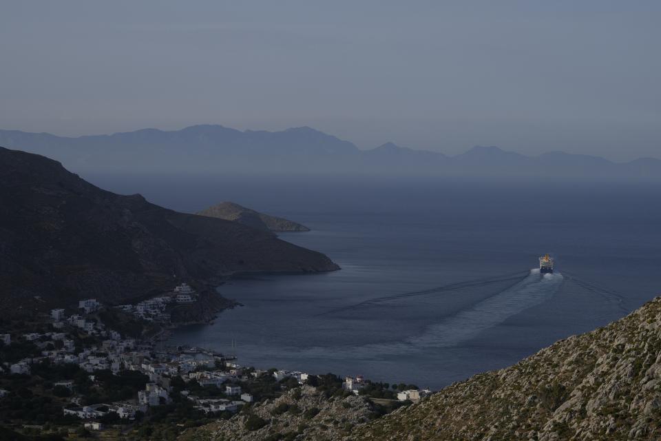 A ferry departs from Livadia port on the Aegean Sea island of Tilos, southeastern Greece, Monday, May 9, 2022. When deciding where to test green tech, Greek policymakers picked the remotest point on the map, tiny Tilos. Providing electricity and basic services, and even access by ferry is all a challenge for this island of just 500 year-round inhabitants. It's latest mission: Dealing with plastic. (AP Photo/Thanassis Stavrakis)