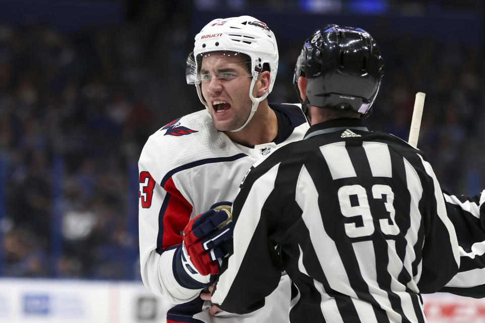 Washington Capitals' Tom Wilson is held back by linesman Brian Murphy (93) as he argues a penalty call during the second period of an NHL hockey game against the Tampa Bay Lightning Monday, Nov. 1, 2021, in Tampa, Fla. (AP Photo/Mike Carlson)