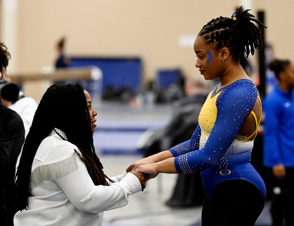 Fisk University gymnastics head coach Corrinne Tarver talks with Naimah Muhammad before Muhammad competes in the floor exercise during the Tennessee Collegiate Classic meet Friday, Jan. 20, 2023, in Lebanon, Tenn. Fisk is the first historically Black university to have an intercollegiate women’s gymnastics team.