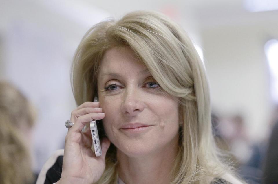 Texas Sen. Wendy Davis, D-Fort Worth, left, makes a phone call to a potential voter during a visit to her campaign headquarters Tuesday, March 4, 2014, in Fort Worth, Texas. Texas is holding the nation's first primary election Tuesday with a political free-for-all in Republican races that could push the state further right, though Democrats are calling it the next big electoral battleground with Davis running for governor. (AP Photo/LM Otero)