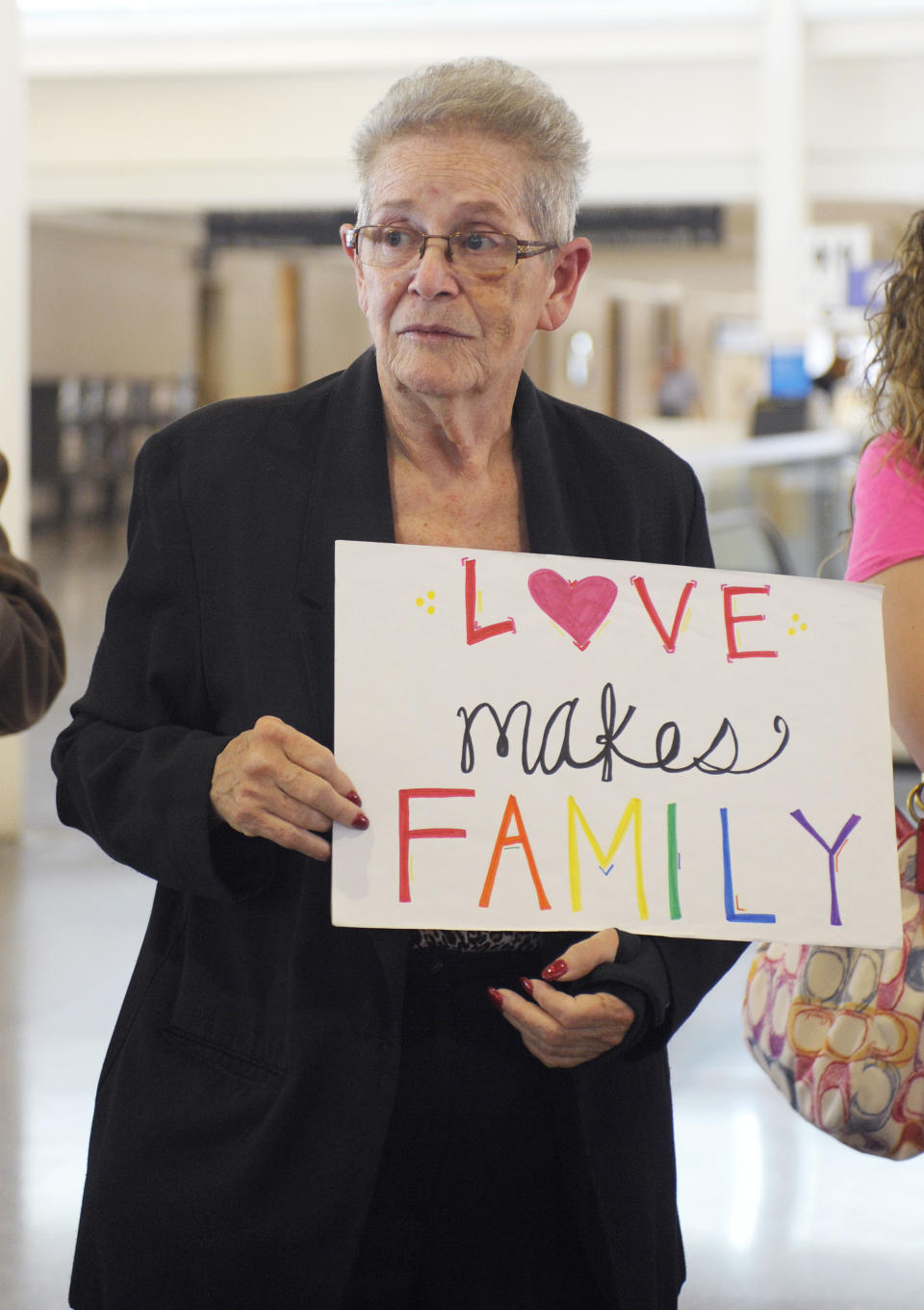 Carolyn Wiley of Tulsa holds a "Love Makes Family" sign as Oklahomans for Equality gathered at Tulsa International Airport with their signs for a send off celebration in support for the plaintiffs in the Oklahoma Marriage Equality lawsuit as they head to the 10th Circuit Court of Appeals in Denver, Wednesday, April 16, 2014. (AP Photo/Brandi Simons)