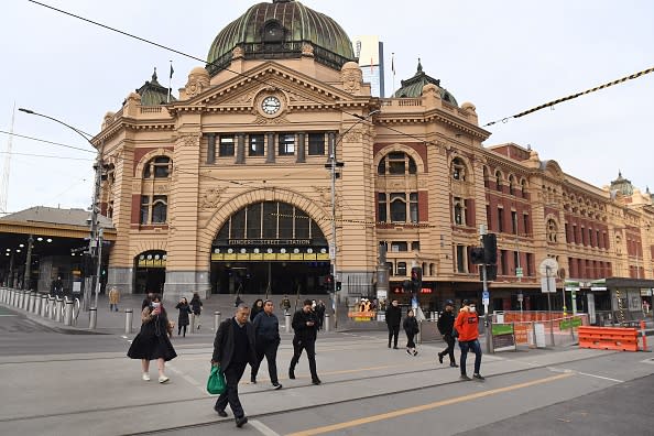 Commuters walk outside the usually bustling Flinders Street station in Melbourne.